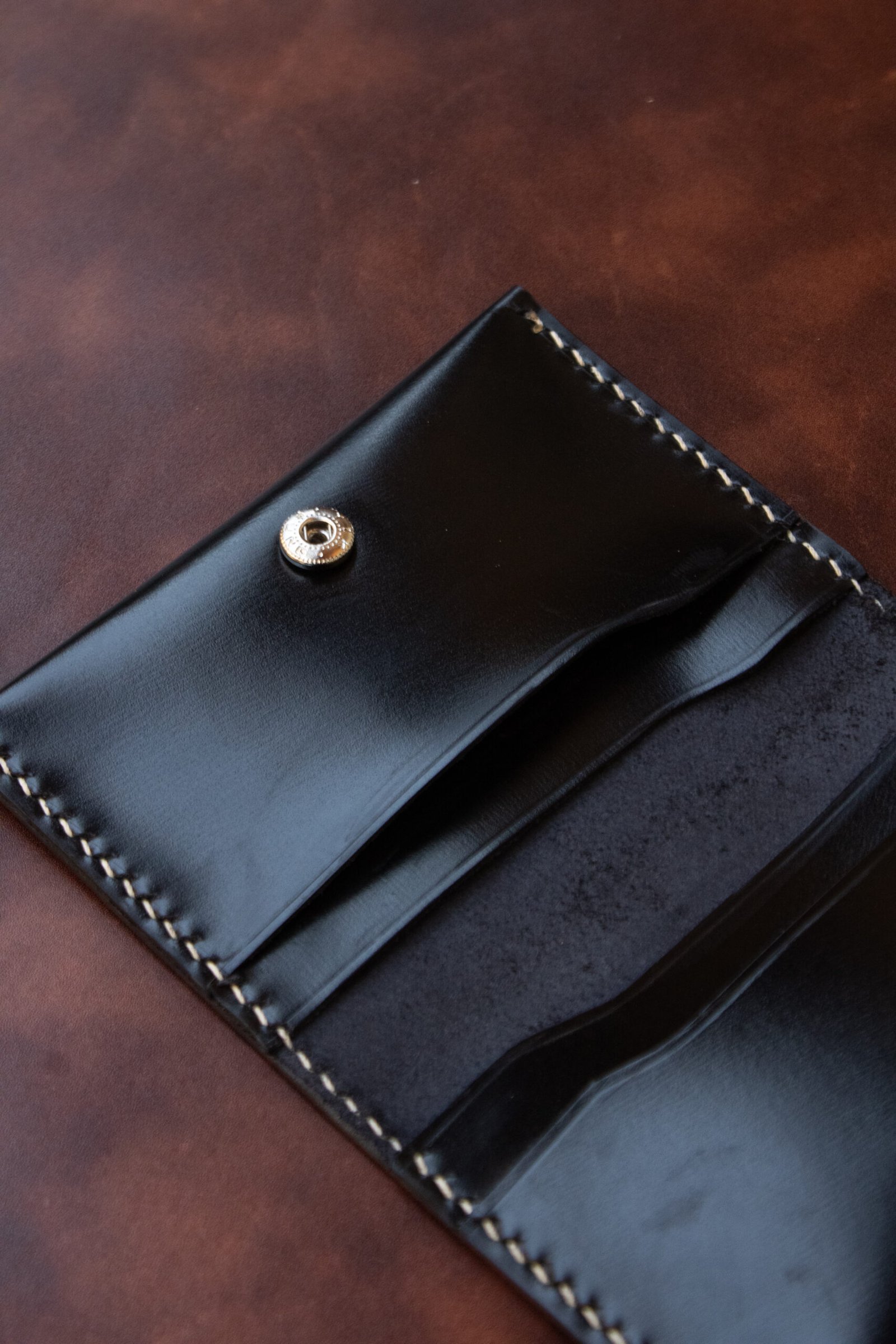 Portefeuille en cuir où l'on voit nettement la forme de la couture point sellier